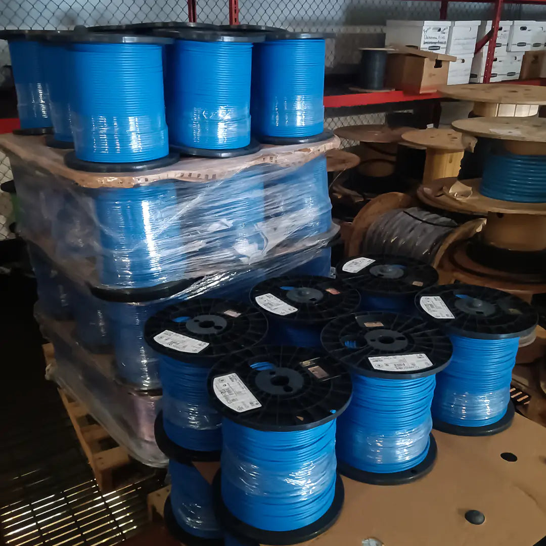 A warehouse with a bulk pallet of CommScope 1071E Cat6 Riser blue cable spools