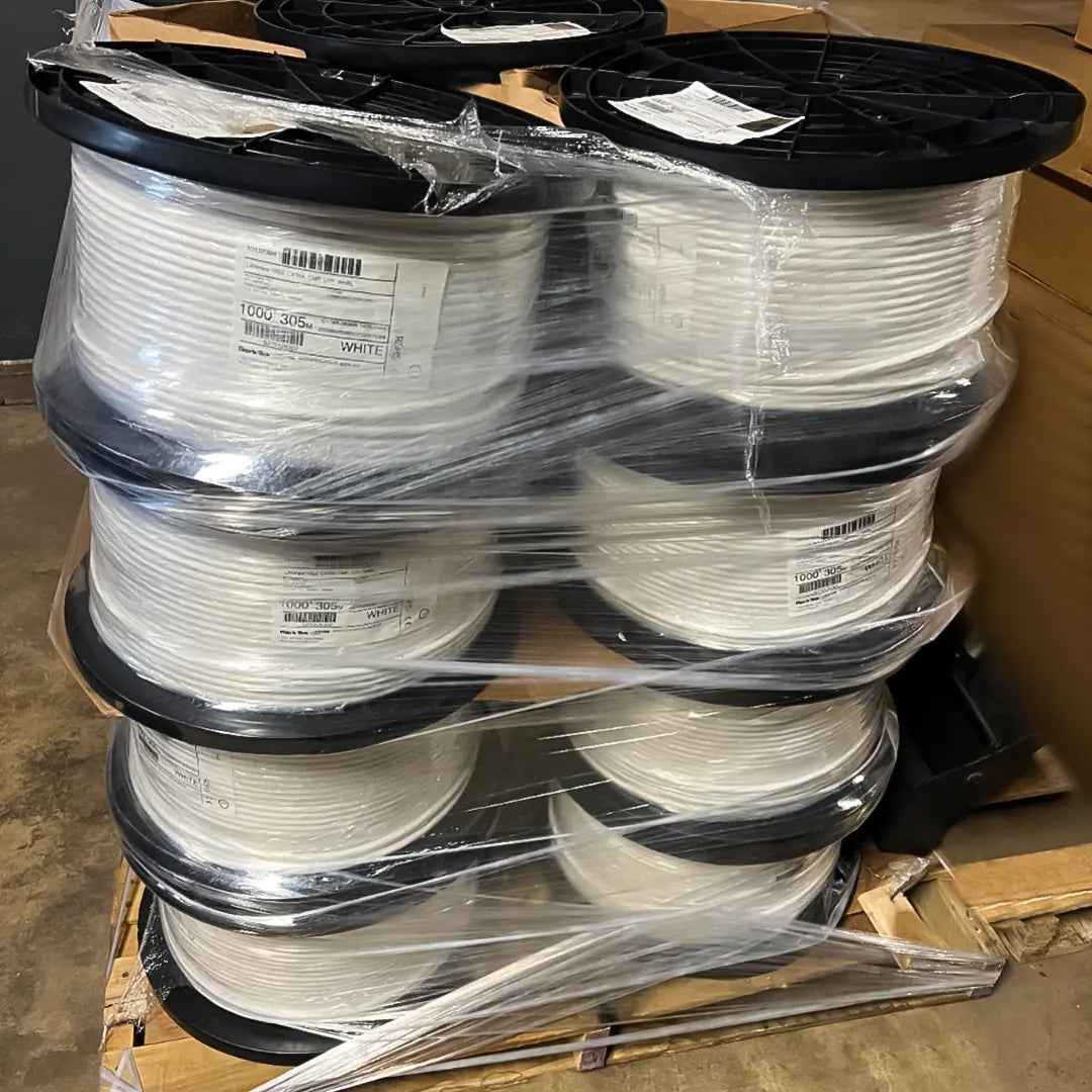 A bulk pallet stacked with spools of Berk-Tek Cat6A Plenum white cable