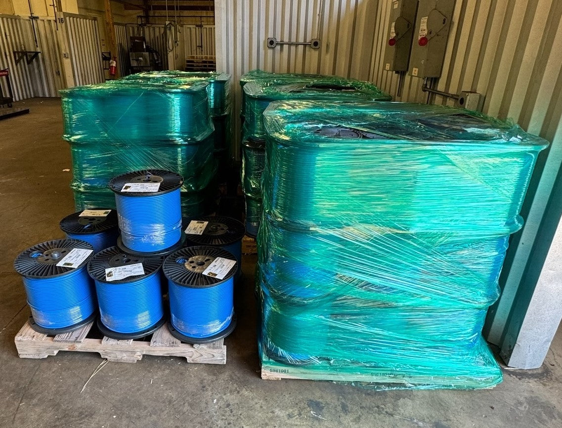 A warehouse with multiple bulk pallets of Cat6A Plenum blue cable spools