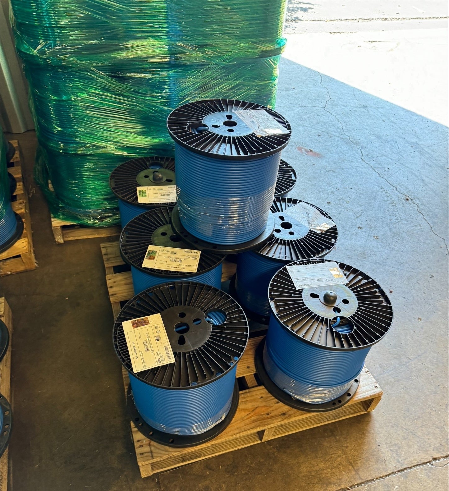 A pallet with several individual spools of Cat6A Plenum blue ethernet cable