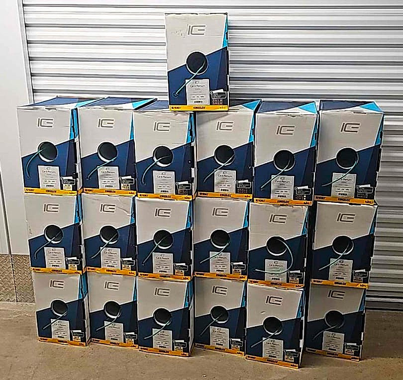 A front view of a pallet stacked with boxes of ICE Cat6 Plenum green cable