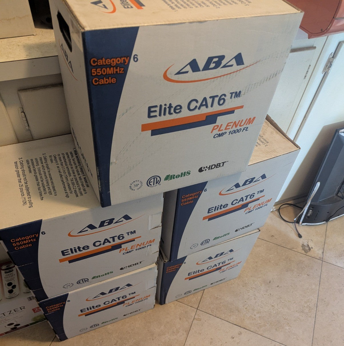Angled view of stacked ABA Elite CAT6 Plenum cable boxes, showing the side panel branding and specification label.